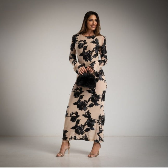 Vestido de fiesta largo y ceñido en tul en crudo con apliques de flores en negro.