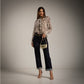 Blusa con chorreras en estampado de serpiente y jeans azul oscuro con cinturón de corazones