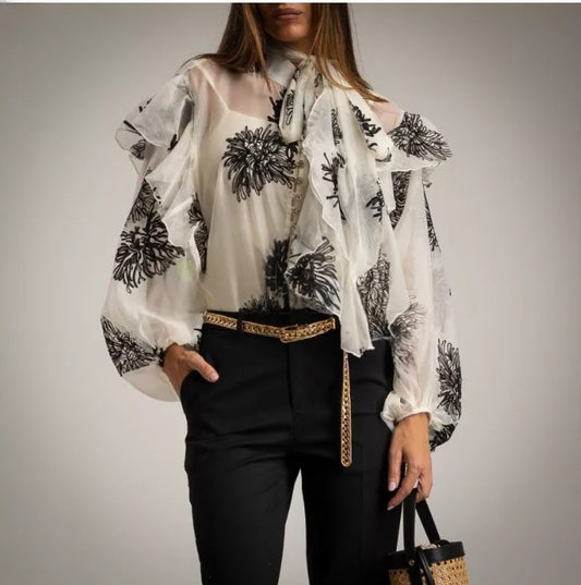 Blusa de organza blanca con flores bordadas negras.