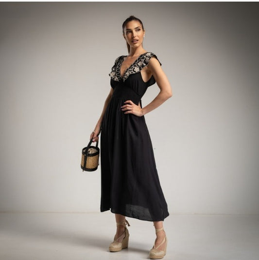 Vestido negro con flores bordadas en la solapa